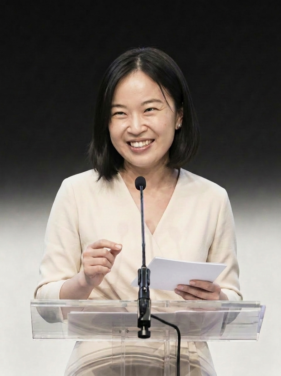 Soh Wan Wei at a glass podium, mic at the lectern — opening an enterprise keynote in Singapore.